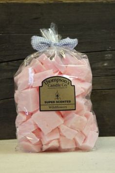 a bag of pink marshmallows sitting on top of a wooden table next to a wall