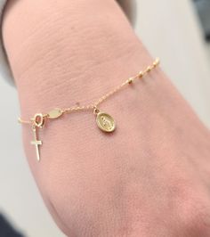 Elevate your faith-inspired style with our Rosary Bracelet featuring a Dangling Miraculous and Cross. Crafted with precision in solid 14K yellow gold, this bracelet exudes elegance and devotion. The delicate beads, each measuring 1.5mm, symbolize prayers and devotion, while the Miraculous medal (8x6mm) and cross (10x6mm) add a touch of sacred beauty. With a comfortable 7-inch length, this bracelet is a timeless expression of faith and grace, perfect for daily wear or special occasions. Details: Rosary Bracelet, Miraculous Medal, Yellow Gold Bracelet, Rosary, Daily Wear, Gold Bracelet, Yellow Gold, Beads, Gold