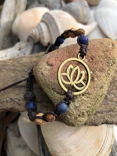 "The lovely and enchanting lotus flower that reminds us to rise up, stay strong and persevere. A thoughtful and loving gift for a friend or loved one facing life challenges or who has risen to the occasion and has fought bravely and courageously. The gorgeous 6mm Sodalite stones are so beautiful paired with the earth toned DZI Agate stones which lend an organic quality to this hand knotted macrame bracelet. The deep dark brown cotton cord really sets off these colors perfectly. The wood beads on Holistic Beaded Meditation Bracelets, Symbolic Adjustable Jewelry For Meditation, Adjustable Symbolic Jewelry For Meditation, Adjustable Inspirational Bracelets With 8mm Beads, Adjustable Nature-inspired Bracelet With Round Beads, Adjustable Flower-shaped Spiritual Bracelets, Adjustable Spiritual Flower Bracelet, Spiritual Braided Bracelets With Round Beads For Meditation, Spiritual Braided Bracelets With 8mm Beads For Friendship