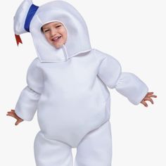 a little boy in a white costume is smiling and standing with his arms out to the side