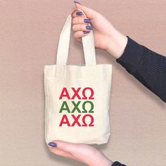 a person holding a bag with the word ajax on it and red letters in green