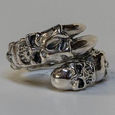 *  Awesome & unusual! Our own design of a dragon claw ring   with skulls running head to head along the ring!*  Hand made in our workshops in Devon*  .925 fully hall marked sterling silver ring*  Available in M - Z*  Special Sizes are available on request Edgy Silver Skull Ring As Gift, Edgy Silver Skull Ring For Gift, Edgy Silver Rings For Streetwear, Silver Edgy Skull Ring, Sterling Silver Skull Jewelry For Streetwear, Silver Punk Claw Rings, Silver Punk Rings For Streetwear, Edgy Silver Skull-shaped Jewelry, Edgy Silver Skull Jewelry