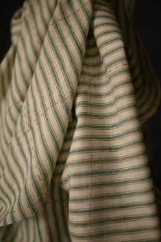 a close up view of a green and white striped shirt with orange dots on it