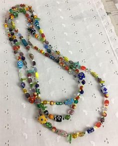 A unique handmade multi-color glass bead necklace. Made with mostly handmade or lampworked glass beads. Perfect for work, or a night out, or with that cute little tee shirt and jeans. The pictures show two necklaces combined. The shorter strand is 26. The longer strand is 58 and is doubled in the Yellow Pearl Earrings, Layered Beaded Necklaces, Grey Pearl Necklace, Three Strand Necklace, Beading Crafts, Long Statement Necklace, Necklace Colorful, Paper Jewelry, Necklace Unique