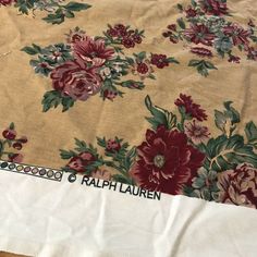 a table cloth with flowers on it is laying on the floor next to a pair of scissors