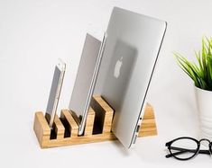 an apple computer sitting on top of a desk next to glasses and a potted plant