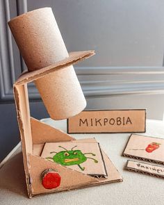 a toilet paper roll sitting on top of a table next to some cards and a hat