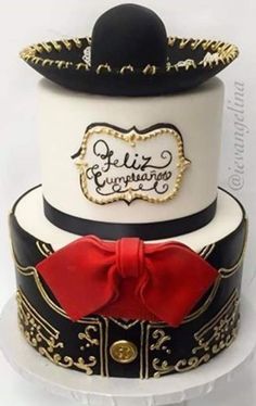 a three tiered cake with a red bow on the top and gold trimmings