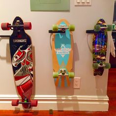 three skateboards are hanging on the wall next to each other in front of a door