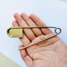 a person holding a pair of scissors in their left hand, with the other one on top of them