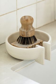 a brush sits in a bowl on the counter