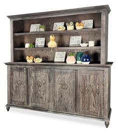 an old wooden hutch with drawers and pictures on the top shelf, in front of a white background