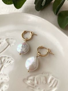 These stunning Coin Pearl Hoop Earrings are the perfect balance of bold and dainty! They make beautiful special occasion earrings, or remove the pearl charm and wear the hoops for an everyday casual style! These are some of the nicest quality Coin Pearls I have come across! Pair them with the matching Del Mar Necklace to create a dreamy Pearl set! * 14mm (removable) genuine Coin Pearl charms * 13mm 14K Gold Filled or 925 Sterling Silver Leverback Hoops * 14/20 gf or 925 stamp for authenticity * Sold as pair * Made with all hypoallergenic materials 🤍 *Please note for the health and safety of my customers, and to uphold the highest quality standards - these earrings are final sale - please dm me with any questions prior to purchase 😊 Shop more Pearl earrings here: https://etsy.me/3w2mRQZ G Handmade Elegant Hoop Huggie Earrings, Elegant Handmade Hoop Huggie Earrings, Elegant Handmade Huggie Hoop Earrings, Wedding Huggie Hoop Earrings With Pearl Charm, Small Hoop Pearl Earrings For Gift, Small Hoop 14k Gold-filled Pearl Earrings For Wedding, Small Hoop Pearl Earrings As Gift For Pierced Ears, Small Hoop 14k Gold Filled Pearl Earrings For Wedding, 14k Gold-filled Small Hoop Pearl Earrings For Wedding