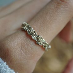 a close up of a person's hand with a gold ring on their finger