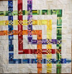 a multicolored quilt is displayed on a table