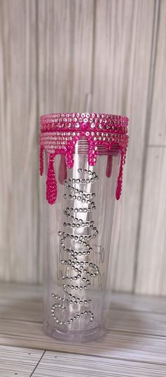 a clear cup with pink beads on it