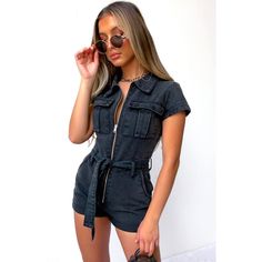 A Must-Have, Effortlessly Cool, And Edgy Chic Denim Playsuit From White Fox Boutique! One Of Those Trendy Hot Pieces That Are Easy To Throw On And Look Instantly Stylish. Designed With A Sexy Fitted Silhouette, Spread Collar, Zip-Up Closure, Cute Short Sleeve, Removable Waist Tie With Belt Loops, Two Front Cargo-Style Pockets, Two Side Pant Pockets, And A Rolled Hem. Comfy And Super Fun Piece! It Will Look Equally Amazing With Sporty Shoes As It Is With A Pair Of Heels. Made From High-Quality De Black Denim Jumpsuit For Spring, Belted Denim Jumpsuit For Workwear, Chic Black Denim Jumpsuit, Summer Denim Belted Jumpsuits And Rompers, High Waist Fitted Utility Jumpsuits And Rompers, Chic Denim Belted Jumpsuits And Rompers, Fitted High Waist Utility Jumpsuits And Rompers, Casual Denim Belted Jumpsuits And Rompers, Fitted High Waist Denim Jumpsuit In Utility Style