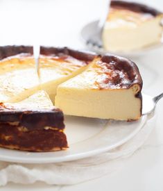 a piece of cheesecake on a white plate with a serving utensil next to it