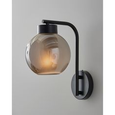 a light that is on the wall next to a glass ball and black pipe with a white background