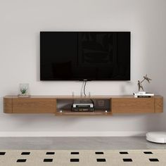 a flat screen tv mounted to the side of a wooden shelf in a living room