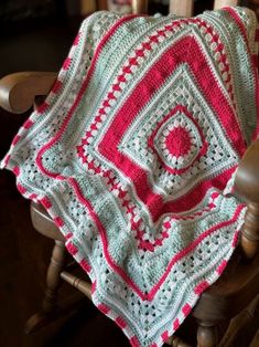 a crocheted blanket sitting on top of a wooden chair