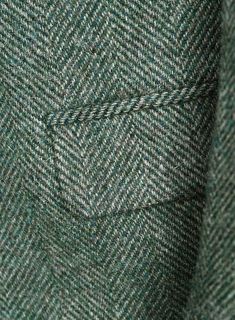 a green and white checkered coat with buttons on the lapel, close up