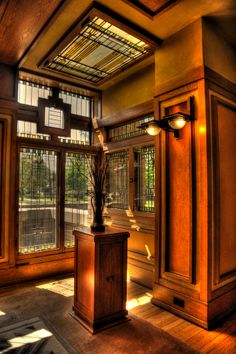 an empty room with large windows and wooden furniture