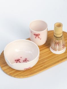 two bowls on a tray next to a small bottle and bamboo container with red writing