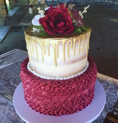 a three tiered cake decorated with red and white icing