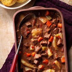 a pink dish filled with beef stew and potatoes