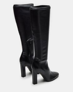 Elevate your style with our ARIA knee-high heeled boot. Crafted with a sleek design, these boots will add a touch of sophistication to any outfit. You can confidently step out in style with a comfortable heel height and secure fit. Perfect for any fashion-forward individual. 4 inch heel height Size 6 measurements: 13.5 inch shaft circumference, 14.5 inch shaft height Size 8 measurements: 14 inch shaft circumference, 15.75 inch shaft height Size 10 measurements: 15 inch shaft circumference, 16.5 Trendy Heeled Boots With Padded Heel For Formal Wear, Tall Boots With Reinforced Heel, Classic High Heel Knee-high Boots, Knee-high Boots With Sculpted Heel, Classic Knee-high Boots With High Heel, Winter Knee-high Boots With Sculpted Heel For Wide Calves, Trendy Wide Calf Knee-high Boots With High Ankle, Trendy High Heel Boots For Formal Occasions, Tall Boots For Evening Wear