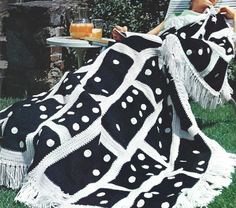 a woman sitting on a lawn chair with a blanket over her and a glass of orange juice in front of her