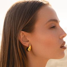 a close up of a person wearing some kind of earring with something in the background