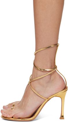 Patent lambskin heeled sandals in gold tone. · Open toe · Single-toe strap · Wraparound ankle strap · Logo embossed at lambskin footbed · Covered stiletto heel · Polished leather sole with rubber injection · Heel: H4.25 Supplier color: Gold Luxury Gold Sandals With 4-inch Heel, Gold Sandals With Sculpted Block Heel, Luxury Formal Sandals With Intrecciato Weave, Evening Sandals With Ankle Strap And Gold-tone Hardware, Gold Sandals With Single Toe Strap For Gala, Luxury Heels With Heel Strap And Single Toe Strap, Luxury Heels With Wrapped Heel And Single Toe Strap, Formal High Heel Sandals With Gold-tone Hardware, Chic Gold Sandals For Gala