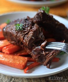 a plate with carrots and meat on it