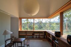 a living room filled with furniture and lots of windows next to a book shelf covered in books