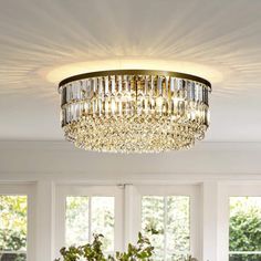 a chandelier hanging from the ceiling in a room with white walls and windows