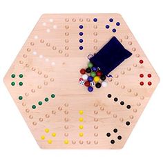 a wooden board with several colored balls and dices on it, next to a blue bag