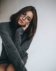 a woman wearing glasses posing for the camera