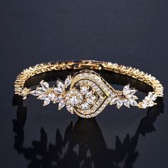 A classy bracelet in art deco vintage inspired style. Featuring intricately faceted cubic zirconia that catch the light from every angle, the bracelet is rhodium / rose gold / yellow gold plated for a flawless finish which perfectly enhances the intricate detailing and conveys a modern take on old elegance. Length: 7" (approx. 18cm); Width: 1" (approx. 2.6cm). Closure is a secure fold-over clasp. Weight: 14g.Choose between Silver, Rose Gold and Yellow Gold finishes. To make your choice select yo Elegant Rose Gold Crystal Bracelet For Anniversary, Glamorous Cubic Zirconia Crystal Bracelet Gift, Elegant Diamond Bracelet With Sparkling Stones For Anniversary, Cubic Zirconia Gold Bangle Bracelet For Party, Elegant Crystal Chain Bracelet For Gift, Party Gold Bangle Bracelet With Cubic Zirconia, Elegant Rose Gold Bracelet For Wedding, Elegant Bracelet With Sparkling Stones For Anniversary, Dazzling Cubic Zirconia Bracelet With Elegant Design