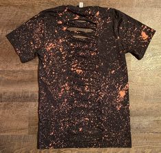 a t - shirt that has been dyed black and orange with holes in the front