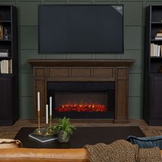 a living room with a couch, fireplace and bookcases in front of it