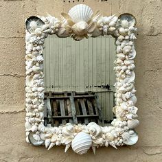 there is a mirror made out of seashells on the side of a building