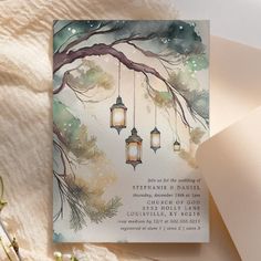 a wedding card with lantern lights hanging from the tree branch and pine cones on it