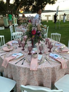 the table is set with pink and white linens