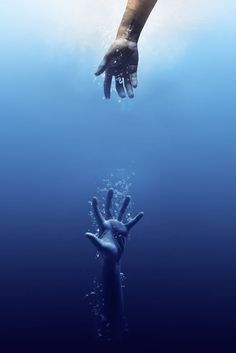 two hands reaching for each other in the water