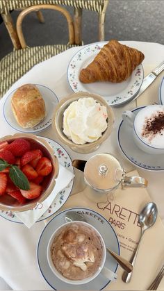 the breakfast is ready to be eaten on the table for two people and they are served with croissants