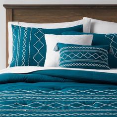 a bed covered in blue and white pillows