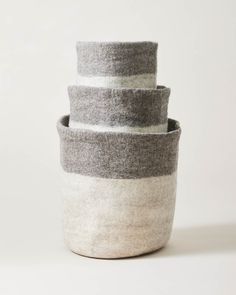 three grey and white striped baskets stacked on top of each other