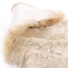 a white sheepskin rug is laying on top of it's back and side